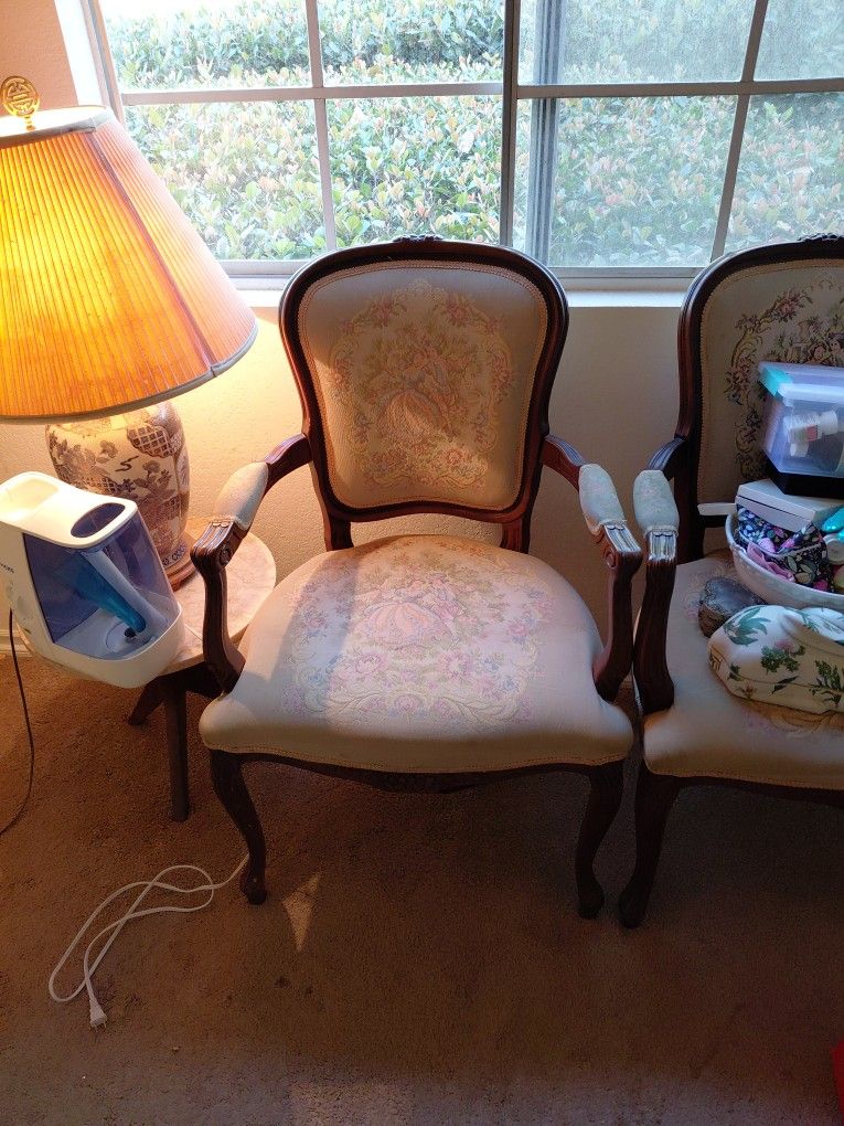 Two matching reproduction armchairs (not antiques/vintage originals).
Dark wood frames with carved details, curved arms, cabriole legs.
Upholstered in