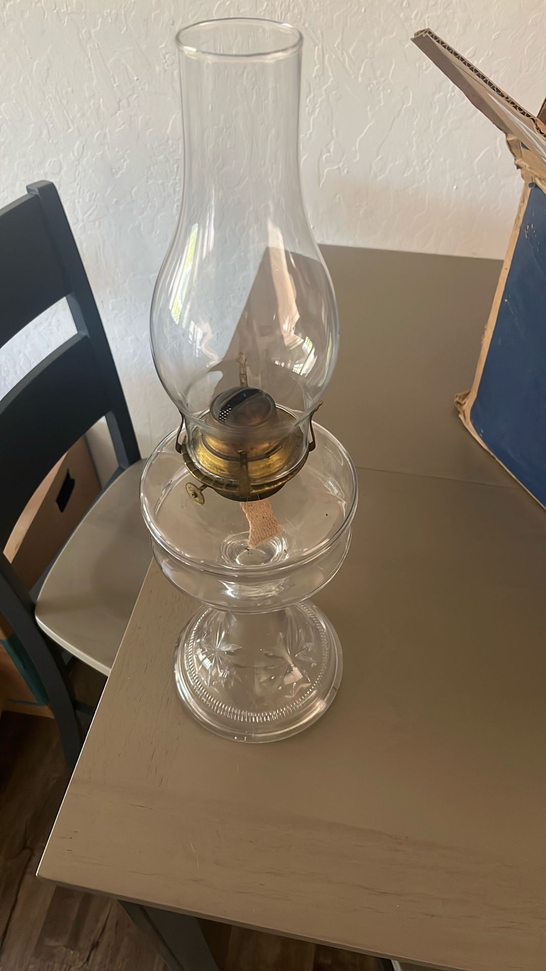 Antique clear glass oil lamp with a burner and chimney.