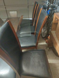 Six faux leather chairs and glass table