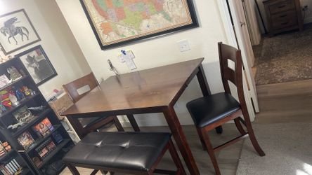 This is a dark wood and black faux leather counter-height dining set