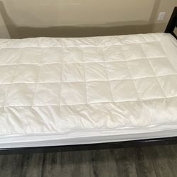 Wooden frame + twin mattress + comforter.