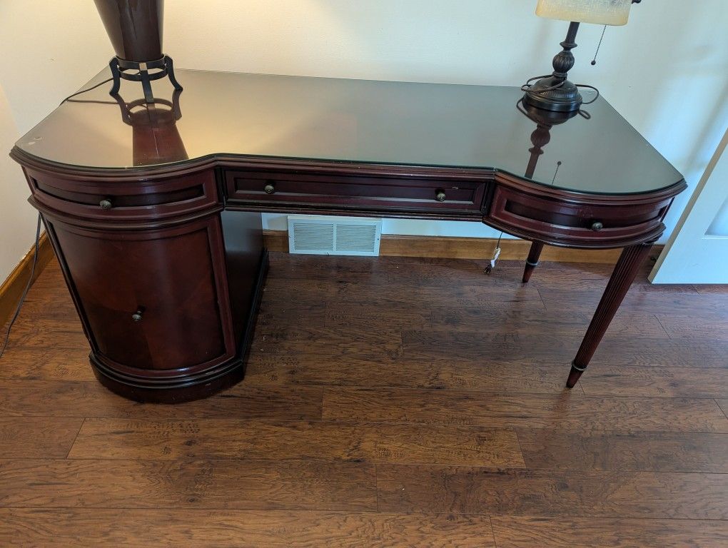 executive style wooden desk with glass top