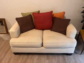Two seater couch with pillows shown