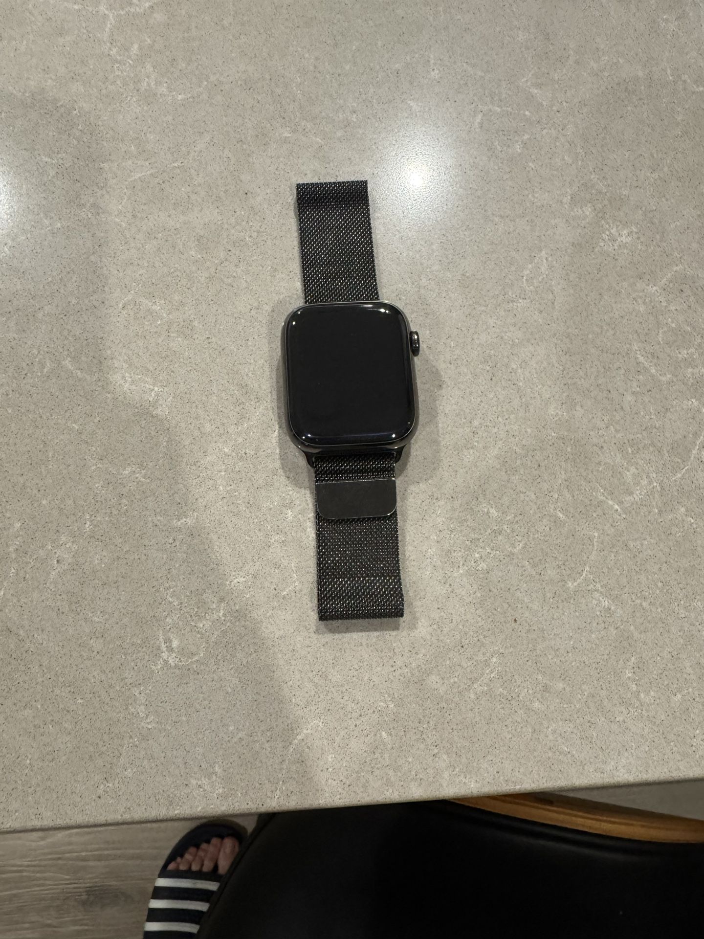 Apple Watch Series 7, 45mm Space Black Titanium Case with GPS + Cellular, paired with Black Milanese Loop.