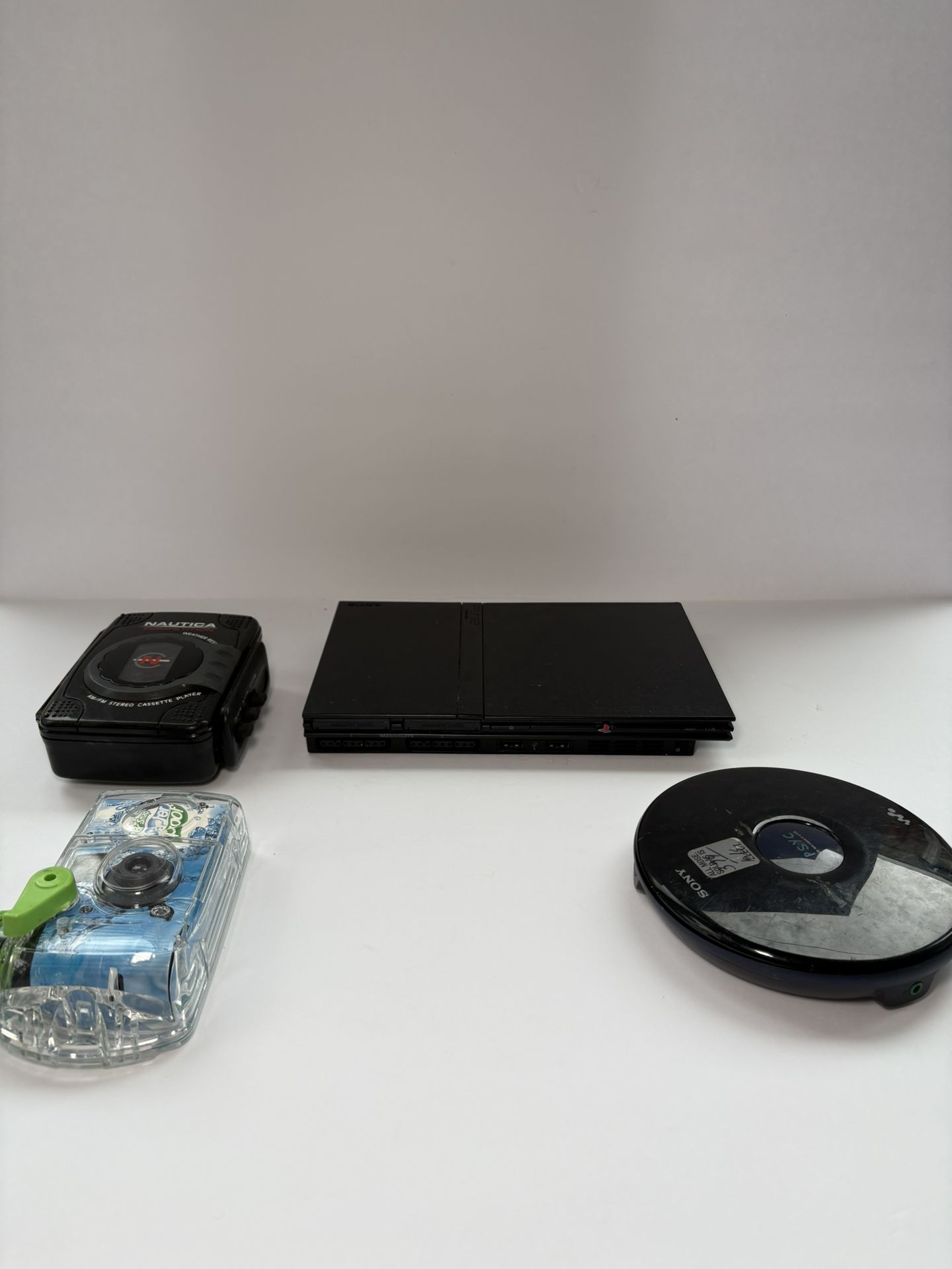 Included in the lot: 	•	1 PlayStation 2 (PS2) 	•	1 Discman (portable CD player) 	•	1 Walkman (cassette player) 	•	1 Waterproof film camera  Important 