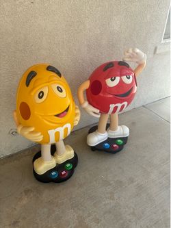 M & M rd and yellow candy store display character with storage tray and rolling wheels