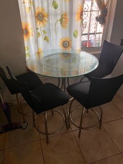 Round glass table with metal base.  4 chairs