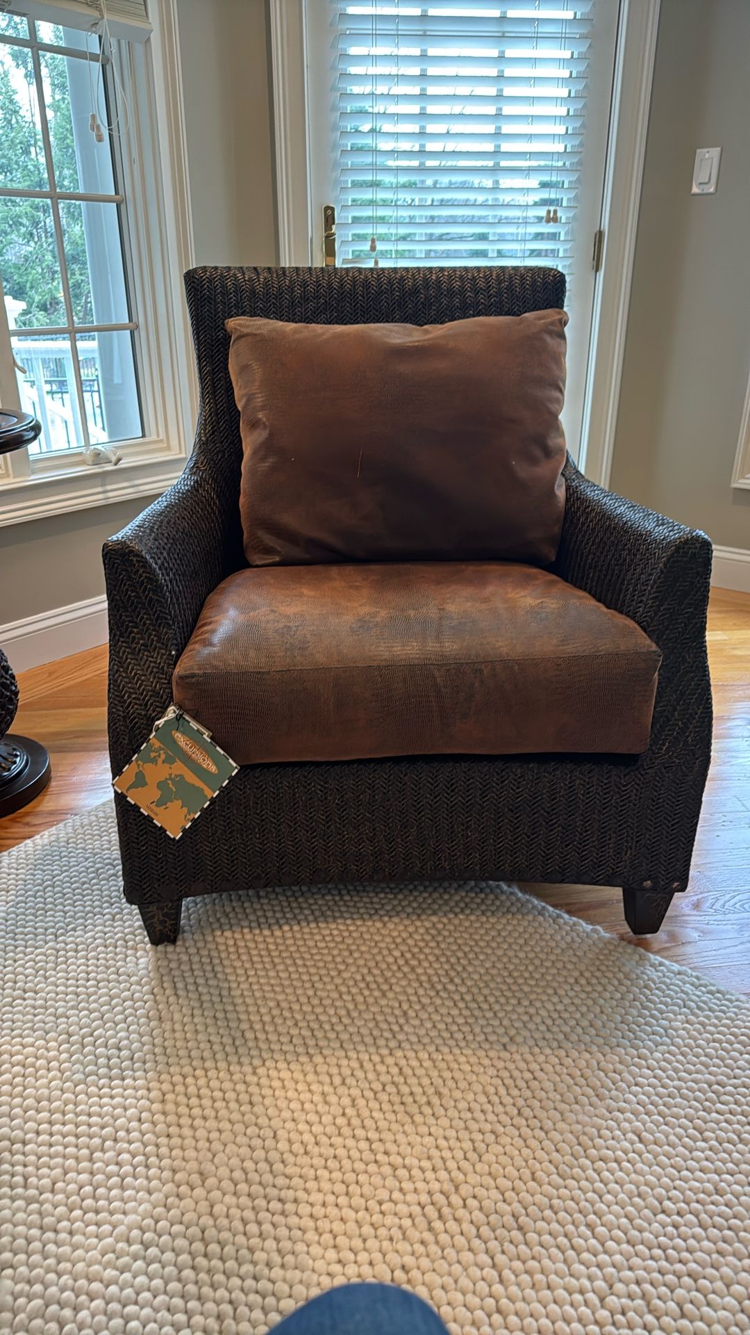 dark brown woven wicker armchair with brown cushions