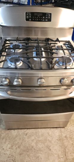 GE Stainless steel gas range with a Whirlpool  microwave oven set