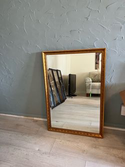 wall mirror with a ornate gilded/gold-finished frame