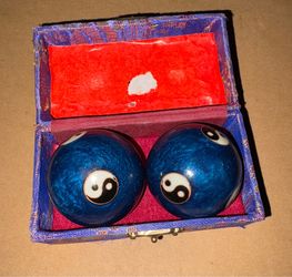 set of blue Chinese Baoding balls with a white-and-black Yin Yang symbol