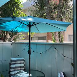 Glass patio table with turquoise umbrella