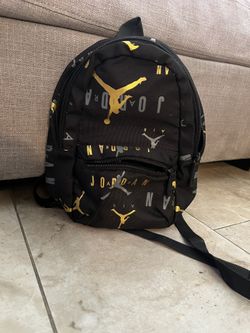 small black and gold Jordan mini backpack. mini mochila pequeña jordan color negro con dorado