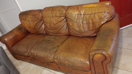 A pair of sofas. Leather. Used but still in one piece.