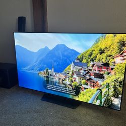 65 LG OLED TV With Soundbar And Large Subwoofer