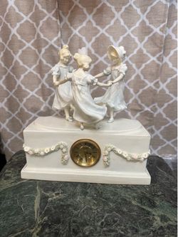 Porcelain clock and candlestick; 12 inches high, 12 inches long, and 5 inches thick.