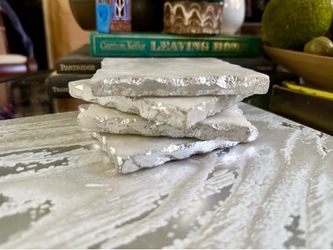 Set of 4 White Crystal Quartz Coasters with Silver Edging   Elegant set of four square coasters is crafted from white crystal quartz. Each piece has a