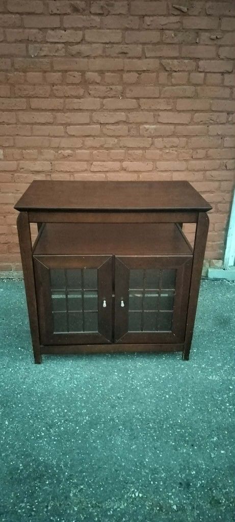 Wooden household shelf and stand unit with enclosure cubby and glass doors
