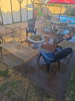 Out door plastic lounge chairs. Tables. And fire place.