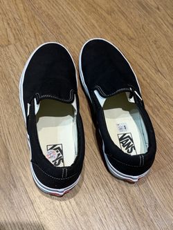 Vans black slip-on sneakers.