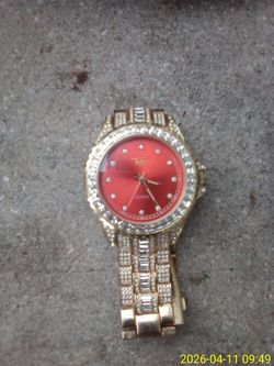 is a Techno Pave men's gold-plated iced-out watch with a red dial.