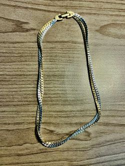 Elegant two-tone chain necklace. Sleek flat links with alternating gold and silver tones. Polished finish. Versatile for layering or wearing alone.