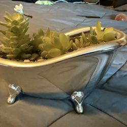 Small silver clawfoot bathtub filled with faux succulent plant and rocks