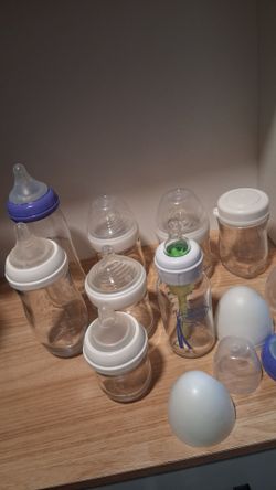 Assortment of glass baby bottles & feeding supplies
