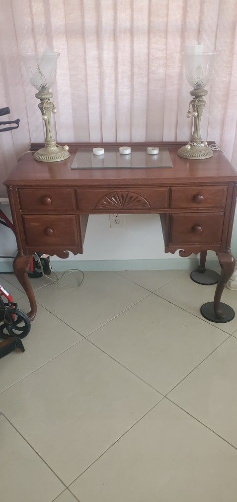 Elegant wooden desk vanity table with two decorative lamps.