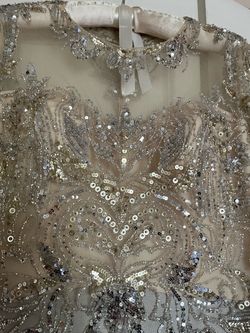 Silver Beaded Sequin Formal Gown it’s for mothers of the bride, the size was 16 but adjusted to size 12 and it’s made by JANIQUE