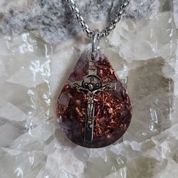 Amara Teardrop Orgonite Pendant – Amethyst, Silver Crucifix & Copper

The Amara Teardrop Orgonite Pendant is a handmade piece featuring Amethyst, a si