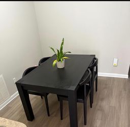 Black dining tabling with 4 black chairs