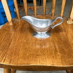 Based on the image, the item is a vintage-style silver-plated or pewter gravy boat. These types of vessels, also referred to as sauce boats, were intr