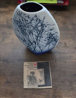 a unique ceramic art vase featuring a botanical motif, accompanied by its matching artistic card and maker's sticker
