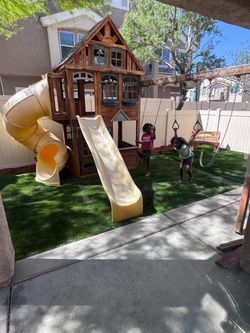Wooden Backyard Playset with Slides and Swings an turf