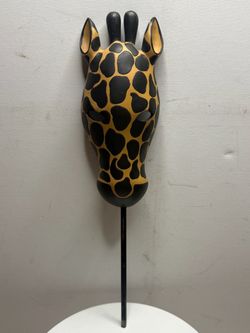 A wall-mounted mask in the shape of a giraffe's head