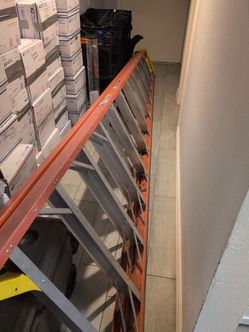 24 ft Werner extension ladder with orange rails, yellow end caps, and aluminum rungs