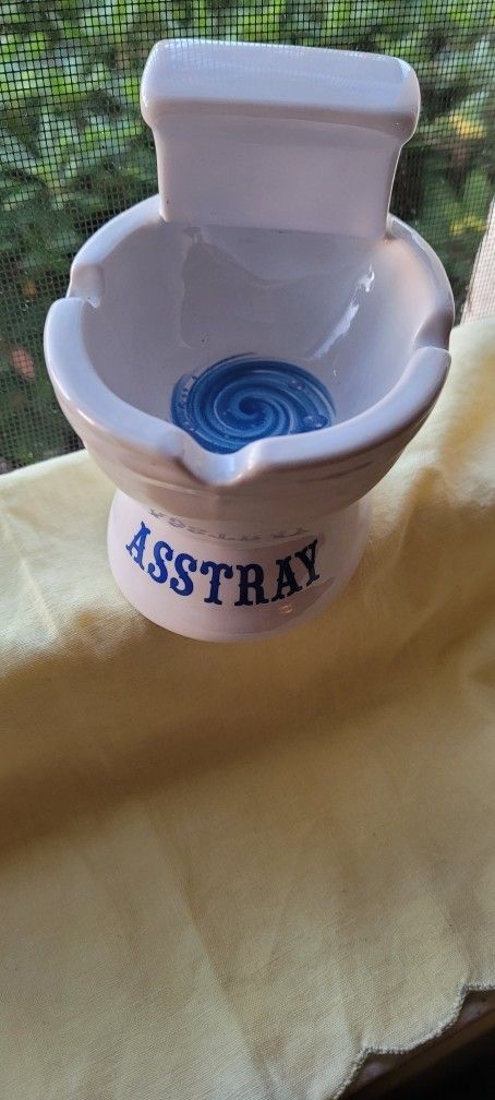 Funny Ashtray, looks like a toilet. The word printed on the front of it is ASSTRAY.