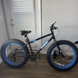 Bicicleta Mongoose Dolomite de 26" con neumáticos anchos, 7 velocidades, color negro