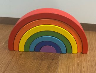 Colorful wooden rainbow stacking arches for open-ended play. Encourages fine motor skills, hand-eye coordination, and creative construction. Includes 