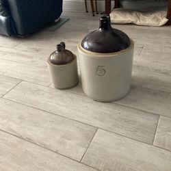 A 2 gallon and 5 gallon whiskey jugs