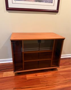 Wooden cabinet w swivel wheels, tinted glass doors
