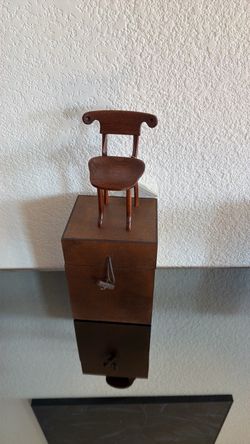 This miniature wooden chair is a detailed scale replica of the iconic Batlló Chair designed by the Catalan architect Antoni Gaudí for Casa Batlló in B