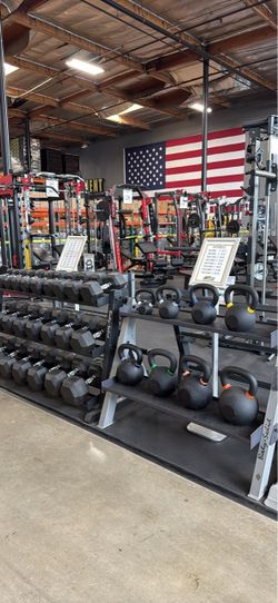 Smith machine squat rack home gym dumbbells kettlebells rubber flooring bench bar leg press weights bumper plates