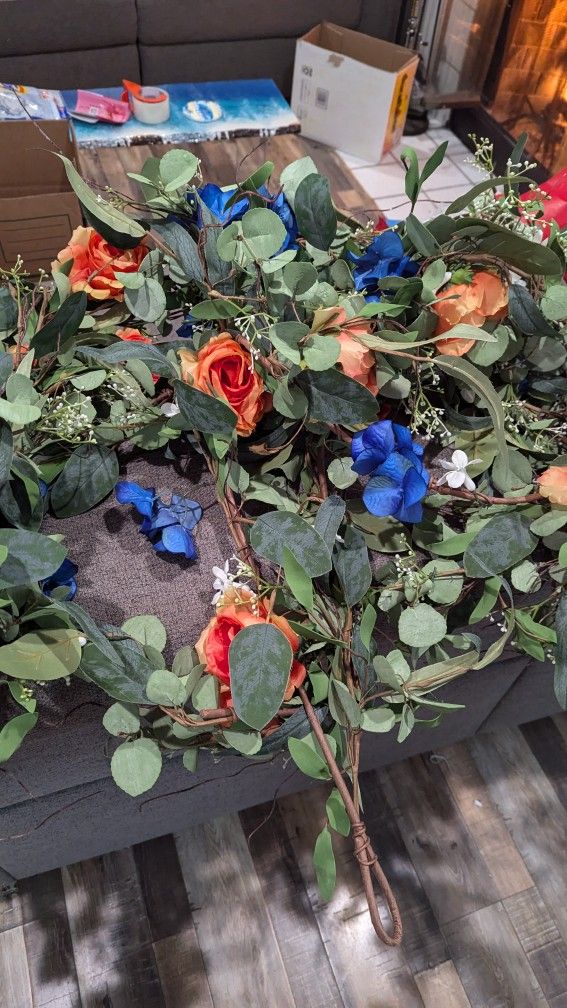 Custom garland that has orange, blue and white flowers.