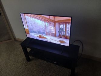 Flat screen VIZIO tv, with black tv stand