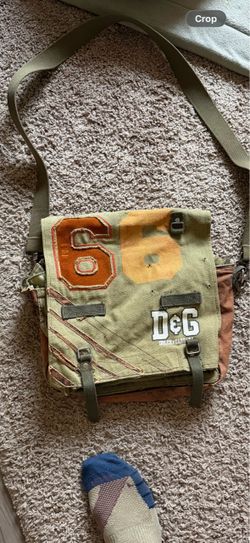This 2000s Dolce & Gabbana shoulder bag features an olive green canvas with black side accents and a brown interior lining.