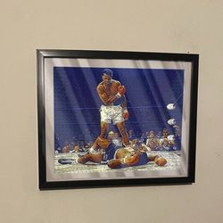 Art piece of Muhammad Ali knocking out sonny Liston in black frame