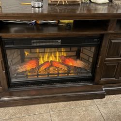 Beautiful dark wood TV stand with built-in electric fireplace. Fireplace works perfectly and gives off heat (great for cozy nights).