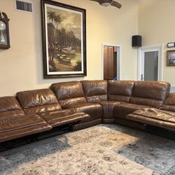 Leather sectional couch with electric motor recliners. 
